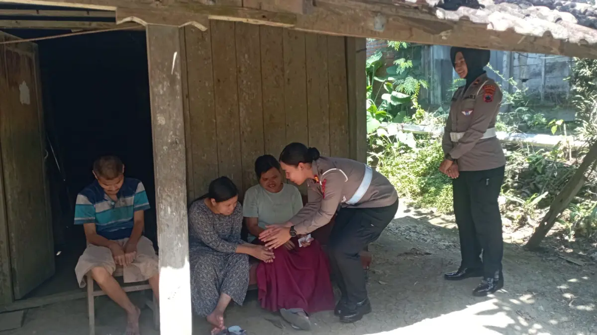 MEMBANTU: Warga disabilitas mental di Desa Lebengjumuk Kecamatan Grobogan saat mendapatkan bantuan Satlantas Polres Grobogan.