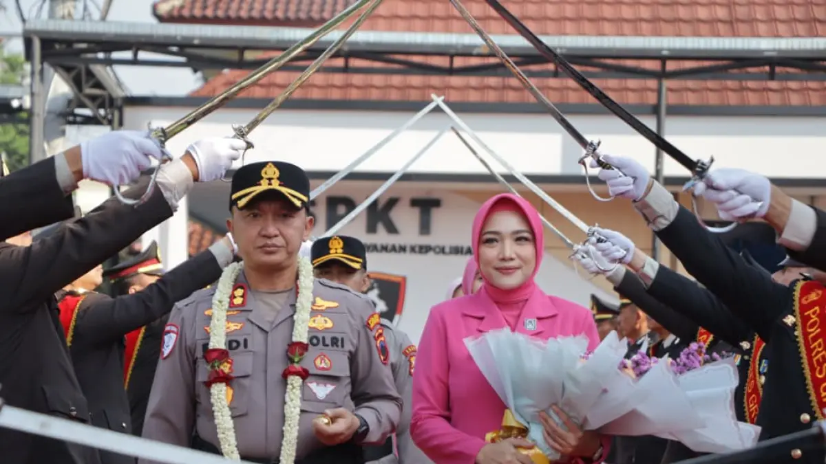 
PEDANGPORA - AKBP Endhie Pratama bersama istri, Ny. Maya Pratama, disambut dengan pedang pora dan kalungan bunga selamat datang di halaman Mapolres Grobogan. (SIROJUL MUNIR/RADAR PATI)
