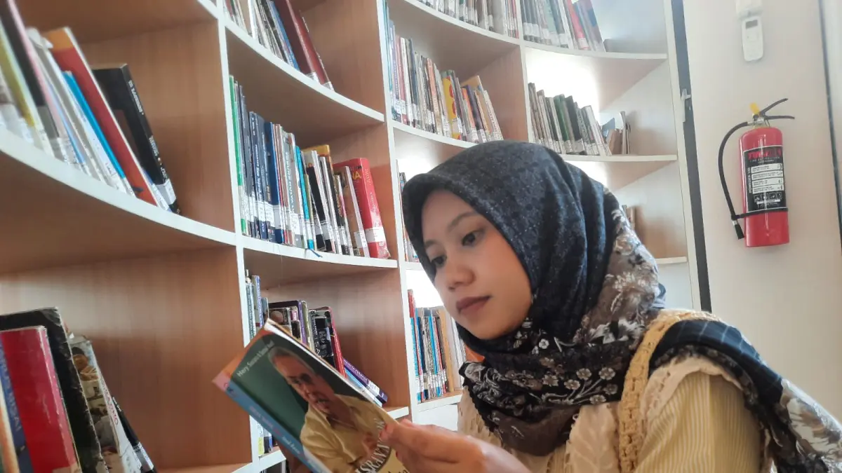 ASIK MEMBACA: Pengunjung memilih-milih buku di rak sembari membaca di Gedung C Perpusda Kudus. (INDAH SUSANTI/RADAR PATI)