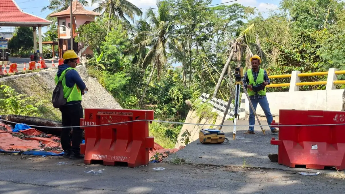 
UKUR: Petugas pembangunan jalan mengukur titik-titik yang nantinya akan dipasang tiang penyangga dengan menggunakan alat teodolit di jalan depan portal masuk wisata Colo, Rabu (8/7). (ANDIKA TRISNA SAPUTRA/RADAR PATI)