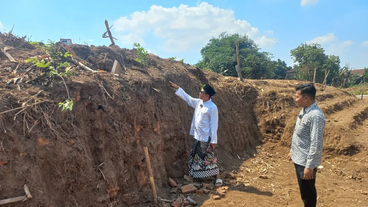 MENJULANG: Pengasuh Ponpes Nailun Najah Assalafy Gus Mad serta Petinggi Desa Kriyan M. Khanafi mengajak menilik kondisi struktur bata kuno di Desa Kriyan yang tampak menghampar luas, serta masih terkubur, pada Selasa (7/7). (FIKRI THOHARUDIN/RADAR PATI)