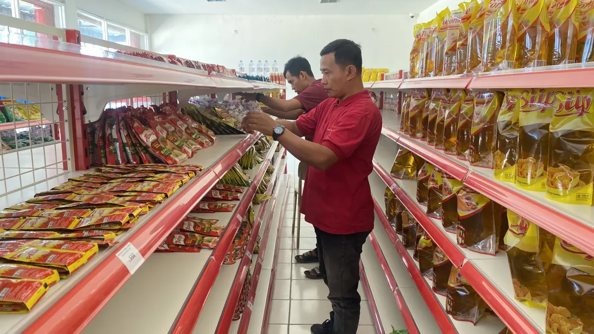 
MENATA: Dua pegawai KDMP Desa Jejeruk menata jajanan di rak penjualan.  (ARIF FAKHRIAN KHALIM/RADAR PATI)
