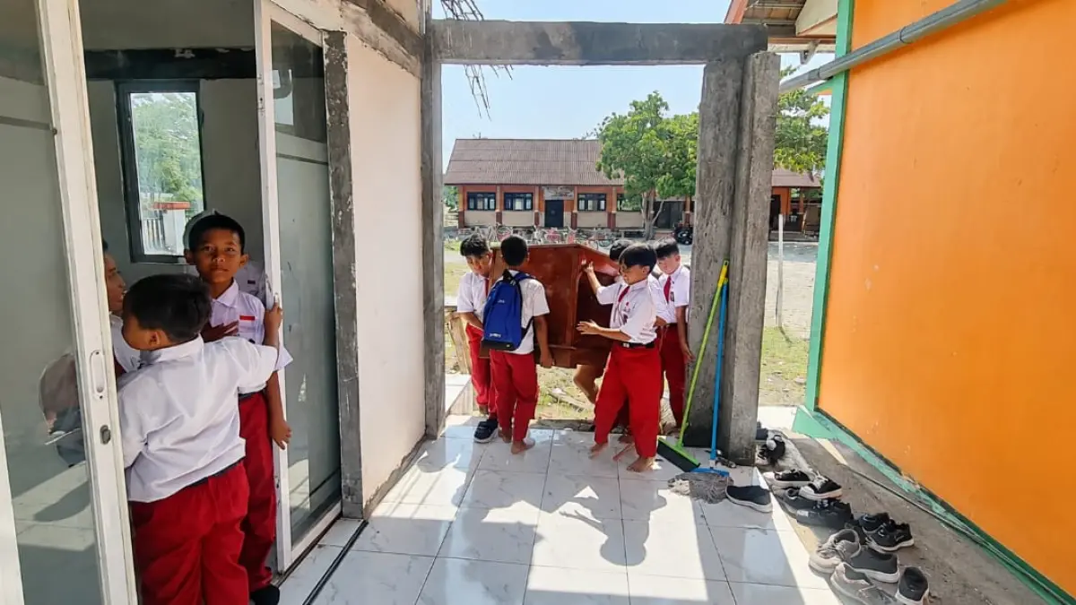BOYONGAN: Anak-anak SDN Tanggirejo Kecamatan Tegowanu Kabupaten Grobogan saat membantu memindahkan meja untuk KBM.