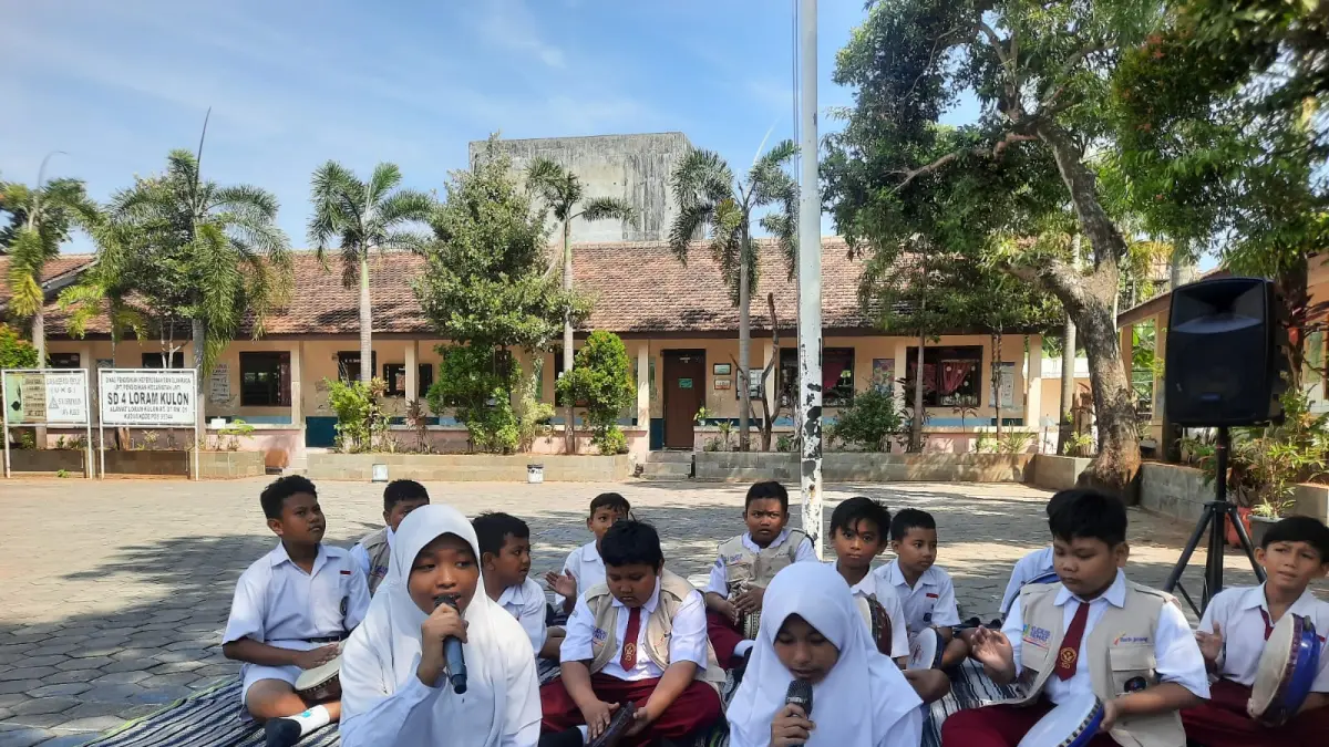 
BELAJAR BERSAMA: Empat murid pertukaran pelajar (pakai rompi) belajar memainkan alat musik rebana bersama murid SD 4 Loram Kulon di halaman sekolah kemarin. (INDAH SUSANTI/RADAR PATI)
