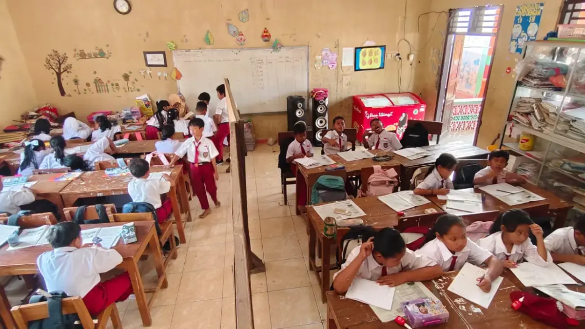 BERDESAKAN: Siswa Kelas 3 dan 4 SD N Tanggirejo, Kecamatan Tegowanu belajar di ruang kelas yang disekat menjadi dua untuk proses belajar mengajar, Senin (27/7). (INTAN M/RADAR PATI)