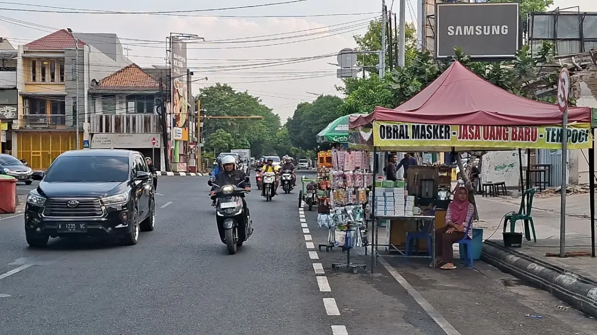 TERHALANG: Sejumlah PKL di kawasan Alun-alun Simpang Tujuh Kudus menghalangi jalur sepeda yang baru jadi, Rabu (29/7). (ANDIKA TRISNA SAPUTRA/RADAR PATI)