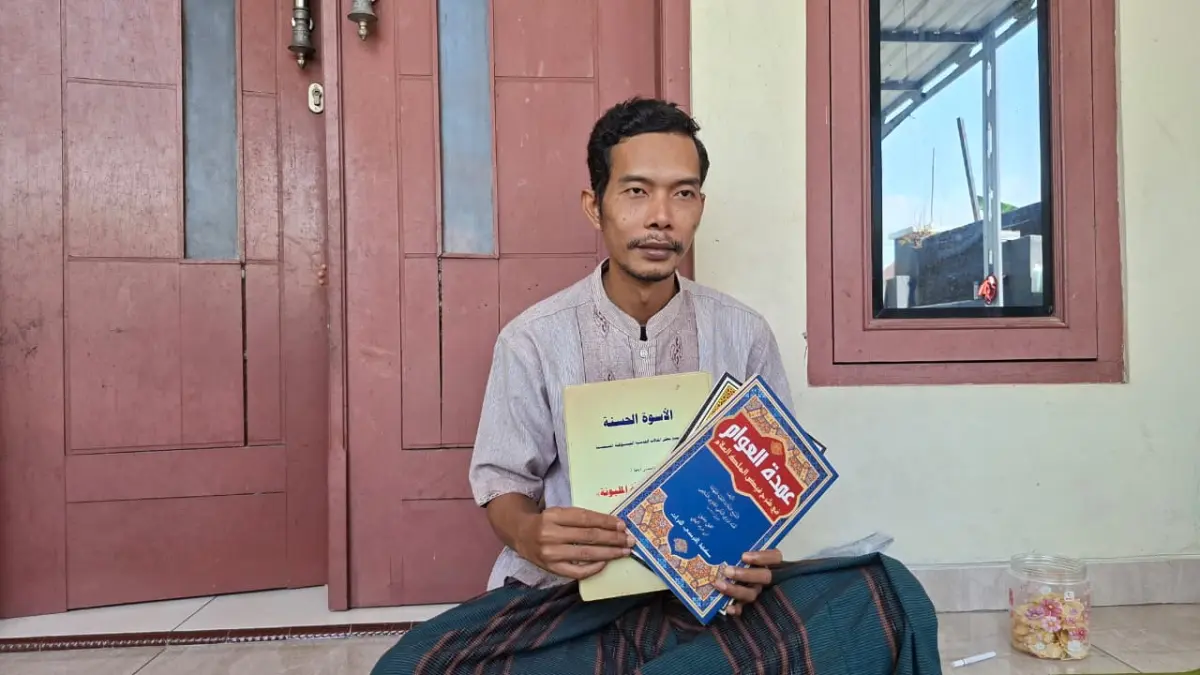 TUNJUKKAN: Mbah Riyan menunjukkan dan membacakan hasil karyanya yang berada di kediamannya. (ANDIKA TRISNA SAPUTRA/RADAR PATI)