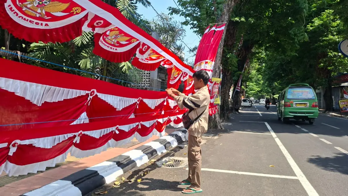 RAPIKAN: Seorang penjual berbagai jenis bendera Merah Putih menata dagangannya di tepi Jalan Pemuda. (ANDIKA TRISNA SAPUTRA/RADAR PATI)