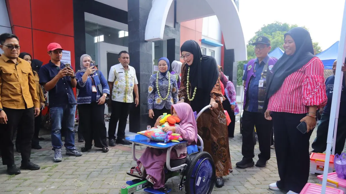 
BERKUNJUNG: Ketua TP PKK Provinsi Jateng Nawal Arafah Yasin mendorong kursi roda anak yang mendapatkan bantuan didampingi Ketua TP PKK Kudus Endhah Endhayani di aula Kecamatan Kota, Kudus. (INDAH SUSANTI/RADAR PATI)