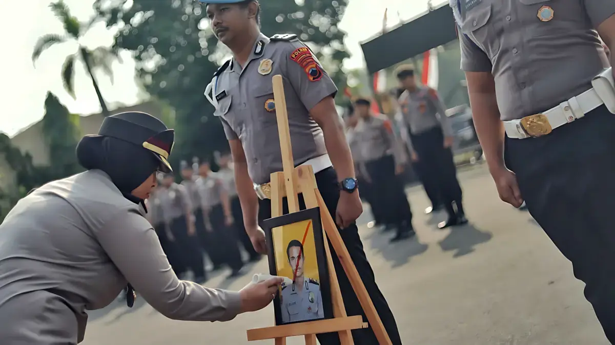 DIBERHENTIKAN: Kapolres Pekalongan Kota AKBP Dies Ferra Ningtias memberikan tanda silang pada foto anggota yang PTDH di halaman Mapolres Pekalongan Kota, Senin (10/8/2026).(DOK. IST)