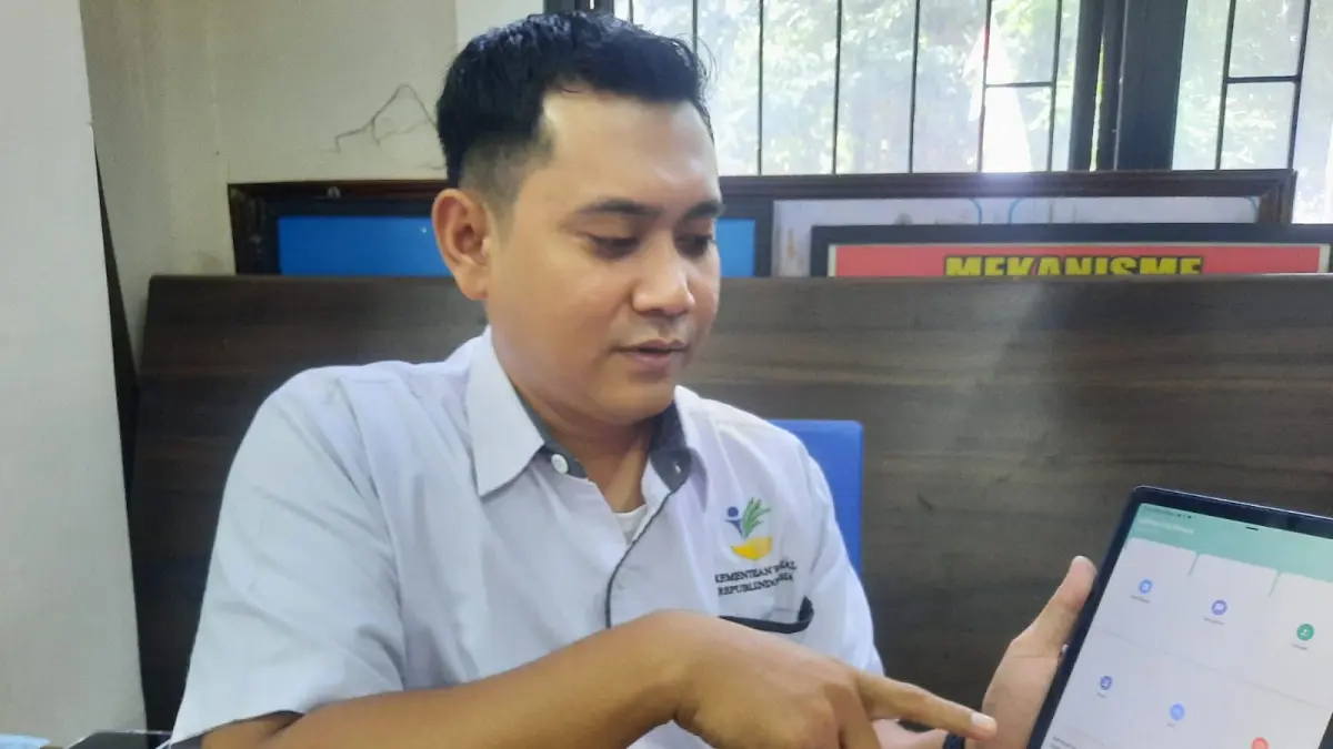 
MENUNJUKKAN APLIKASI: Ketua Tim PKH Kudus Yazid Bustomi menunjukkan aplikasi Cek Bansos di ruang kerjanya. (INDAH SUSANTI/RADAR PATI)

