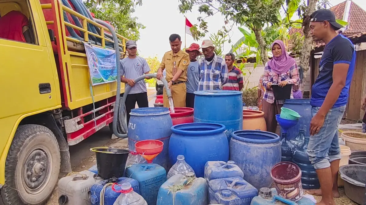 DROPING AIR BERSIH – Warga Desa Kenteng, Kecamatan Toroh antri mengambil air bersih bantuan dari organisasi ikatan alumni SMK N 2 Purwodadi, Senin (31/8)