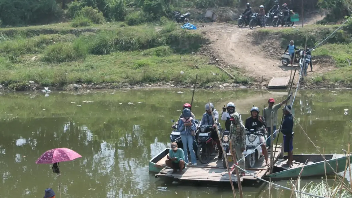 MENYEBRANG: Warga saat memanfaatkan perahu kayu di bawah jembatan Lusi Putat.