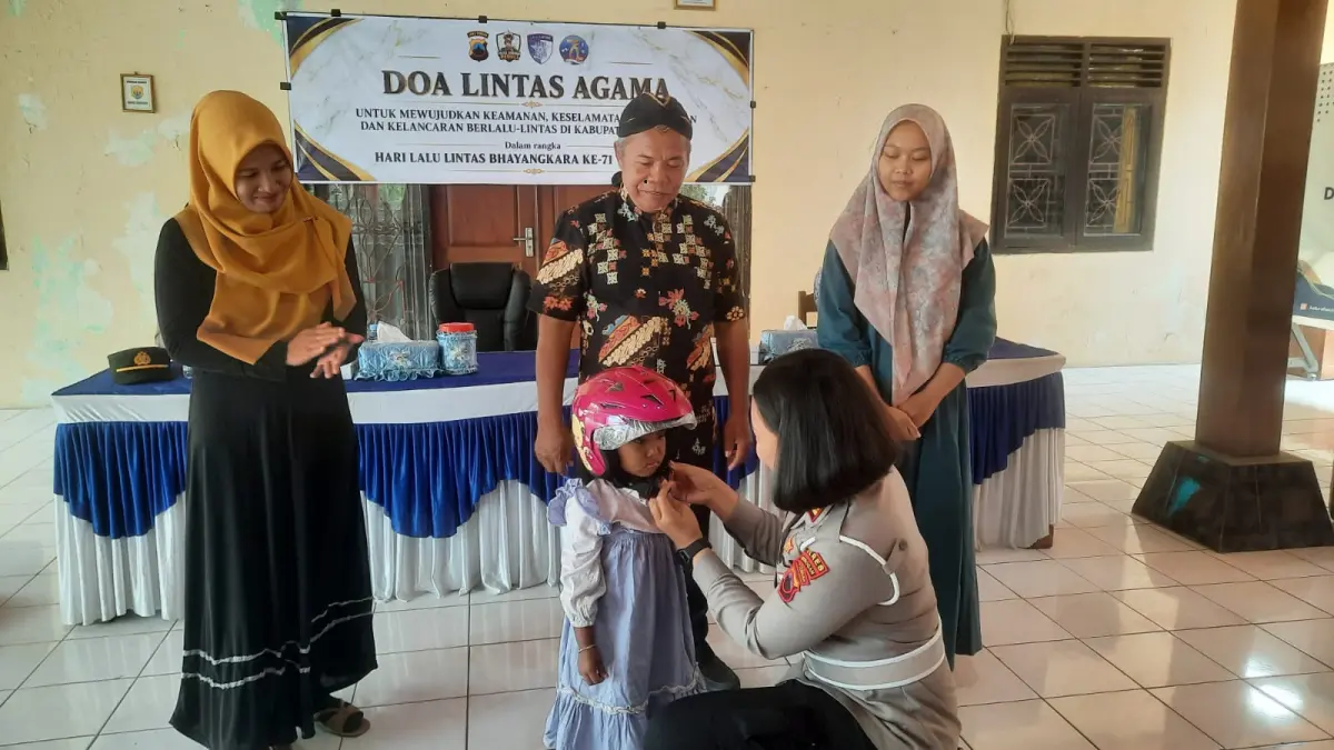 HADIAH: Kasat Lantas Polres Grobogan AKP Kumala Enggar Anjarani saat memberikan hadiah helm ke anak.