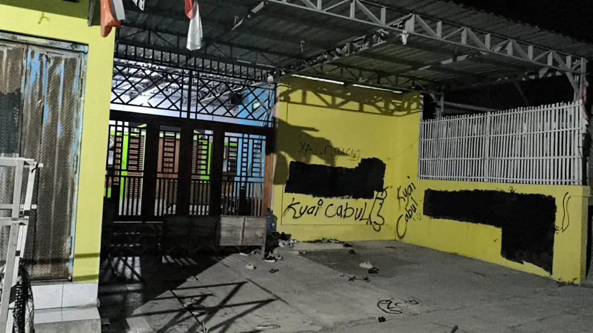 ANDRE FAIDHIL FALAH/RADAR KUDUS
DICORET: Warga menulisi tembok rumah kiayi di Kecamatan Kayen tadi malam.