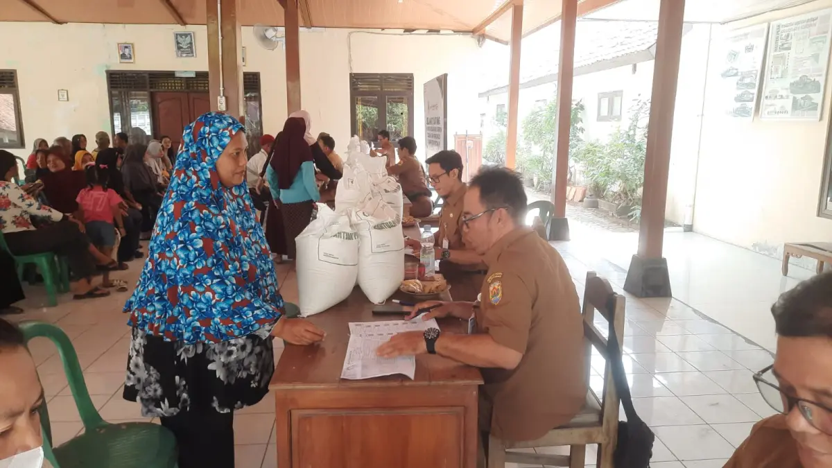 BANTUAN: Warga Kelurahan Kuripan Kecamatan Purwodadi saat menerima bantuan beras 30 kilogram.