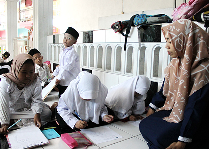 MENDIDIK SEPENUH HATI: Guru Madin At-Tohir Nur Azizah mengejar santrinya, Senin (11/9). (VIVIN AGUSTIN HARTONO/JPRM)