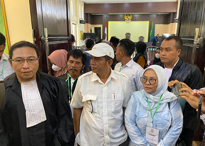 BERI PENJELASAN: Fauzan Adima (topi putih) didampingi istri dan kuasa hukumnya menghampiri wartawan di PN Sampang. (MOH. IQBAL AFGANI/JPRM)