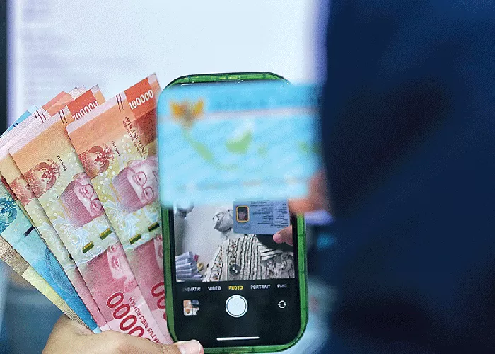 PRAKTIS: Tak perlu bertemu langsung, peminjam bisa mendapatkan uang yang dia butuhkan dari pinjol asal mengisi formulir dan mengunggah swafoto sambil memperlihatkan KTP. (IMAM HUSEIN/JAWA POS)