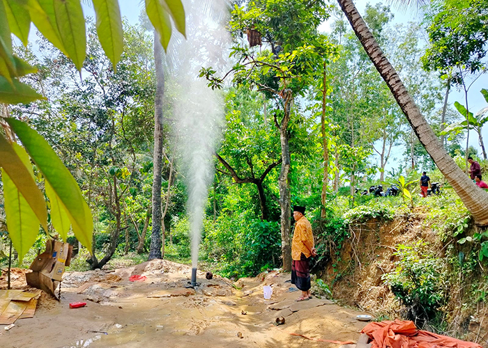 BAHAYA: Warga berada di sekitar semburan air sumur bor di Desa Kadur, Kecamatan Kadur, Pamekasan.&nbsp;(LAILIYATUN NURIYAH/JPRM)