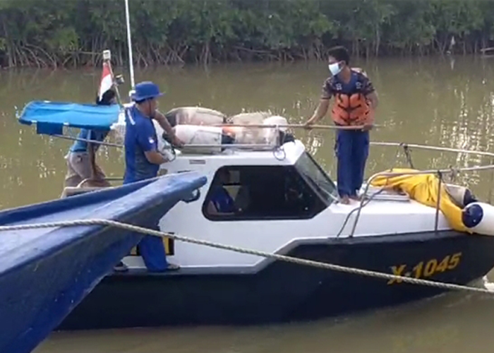 HATI-HATI: Petugas mengevakuasi mayat yang ditemukan di perairan Pulau Mandangin, Kamis (4/1). (POLRES SAMPANG UNTUK JPRM)