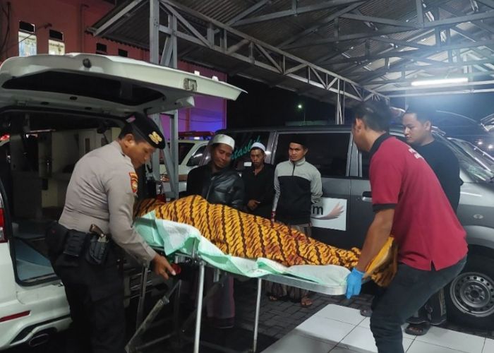 TURUNKAN: Petugas menurunkan jenazah untuk dilakukan autopsi di RSUD Syamrabu Bangkalan. (RadarBangkalan.id)