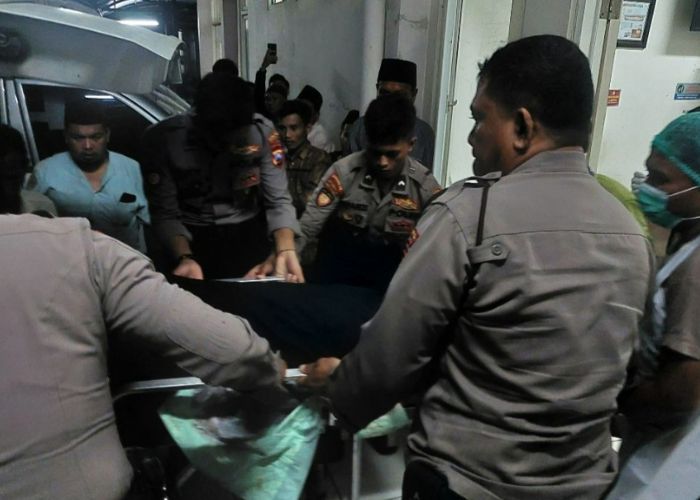 KAWAL KETAT: Petugas keamanan Polres Bangkalan mengeluarkan mayat korban dari ambulan di RSUD Syamrabu Bangkalan pada Jumat (12/1) malam. (Radarbangkalan.id)