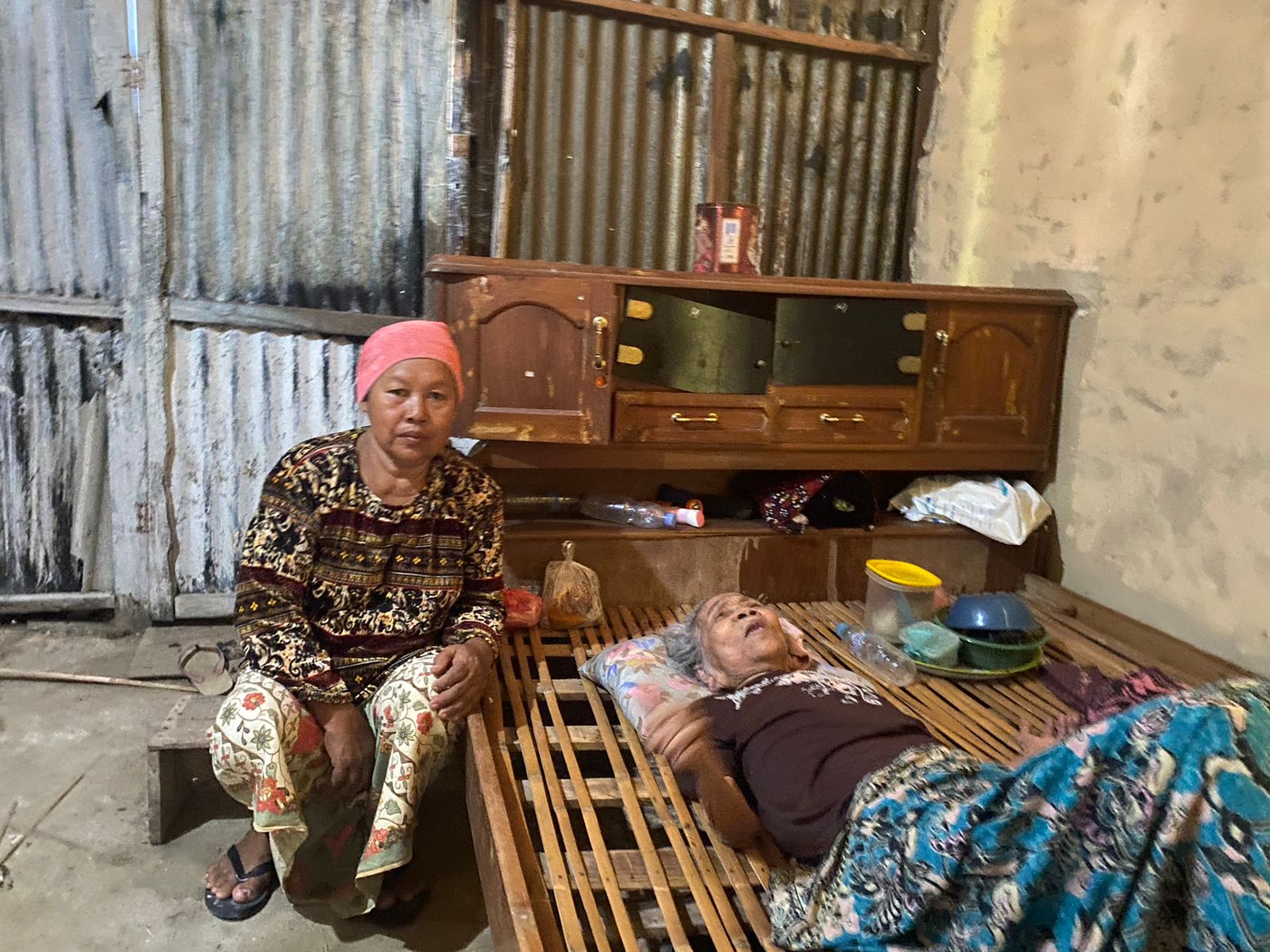 TIDAK MAMPU: Badriah menemani Jumanti yang terbaring di atas dipan saat ditemui di Dusun Tlagah, Desa Banyoning Daja, Kecamatan Geger, Senin (15/1). (AYU LATIFAH/JPRM)