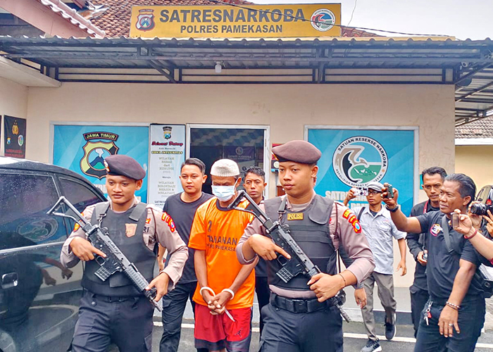 MELANGGAR HUKUM: Ipung Nur Kholis dikawal aparat kepolisian saat rilis ungkap kasus di Polres Pamekasan. (UBAIDILLAHIR RA&rsquo;IE/JPRM)