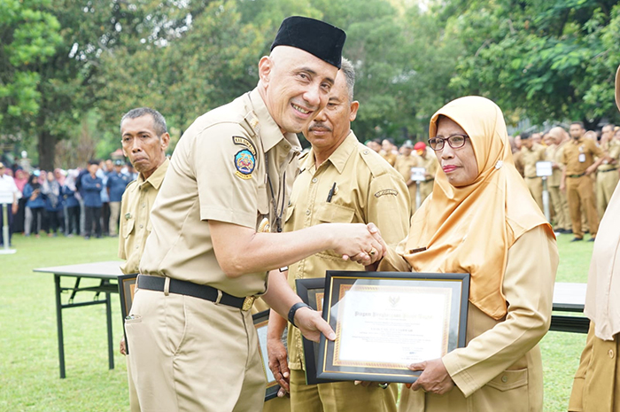 APREASI: Pj Bupati Bangkalan Arief M. Edie menyerahkan piagam penghargaan kepada ASN yang memasuki masa pensiun di halaman kantor pemkab. (PROKOPIM UNTUK Radarbangkalan.id)