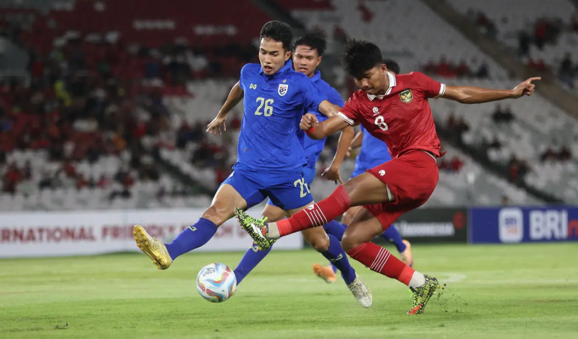 Striker Timnas Indonesia U-20, Arkhan Kaka (kanan) melepaskan tendangan yang berusaha diblok bek Thailand U-20, Puttaburin Jannawan pada laga uji coba di Stadion USBK (Foto: Bola.COM)