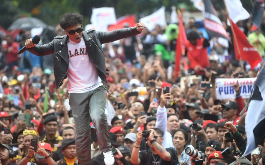 Vokalis Slank Kaka beraksi saat kampanye terbuka perdana capres-cawapres nomor urut 3 Ganjar Pranowo-Mahfud MD bertajuk Hajatan Rakyat di Lapangan Tegalega, Bandung, Jawa Barat. (Foto: ANTARA.COM)