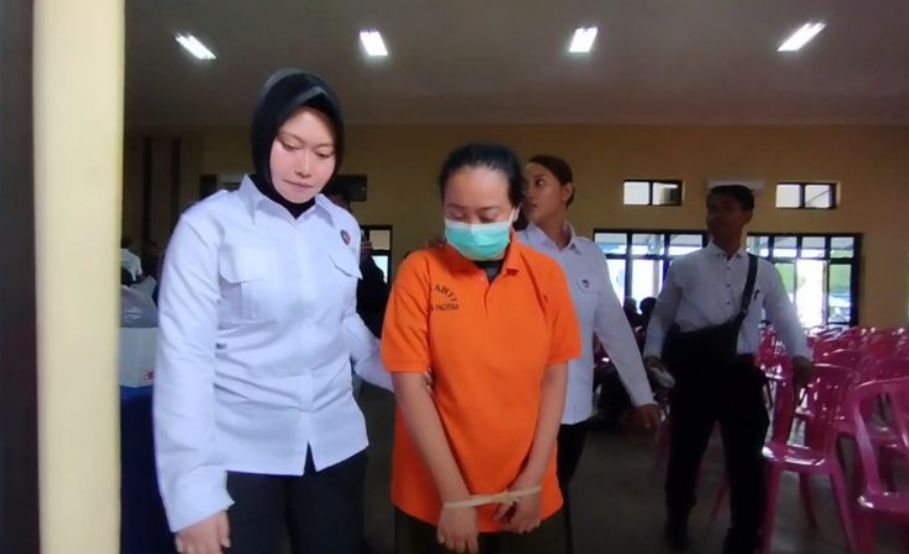 Polwan Polres Pacitan membawa tersangka pembunuhan yang menewaskan seorang siswa MTs di Kecamatan Sudimoro Kabupaten Pacitan Jawa Timur, dengan cara di racun sianida. (Foto: Kompas.com)