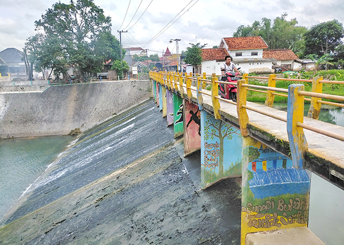 TITIK ASESMEN: Seorang pengendara motor melintas di jembatan bendungan Kelurahan Tunjung, Bangkalan. (VIVIN AGUSTIN HARTONO/JPRM)