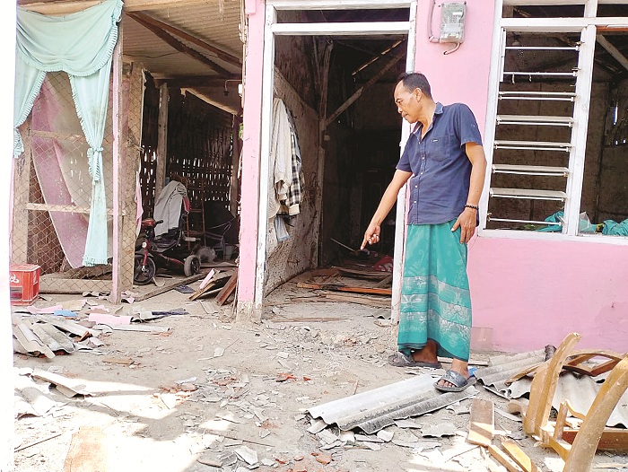 RUSAK PARAH: Kusyairi menunjukkan posisi ledakan bondet di depan pintu rumahnya, di Desa Nyalabu Daya, Kecamatan Kota Pamekasan, Selasa (20/2). (UBAIDILLAHIR RA&rsquo;IE/JPRM)