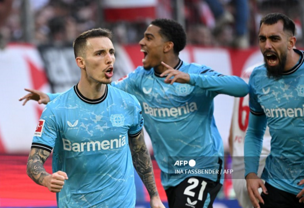 Bek Bayer Leverkusen, Alex Grimaldo, merayakan gol ke gawang Koeln (AFP)
