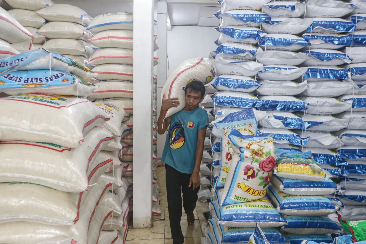 Pekerja mengangkut beras di Pasar Parung, Kabupaten Bogor, Jawa Barat, Senin (4/3/2024). (SALMAN TOYIBI/JAWA POS)