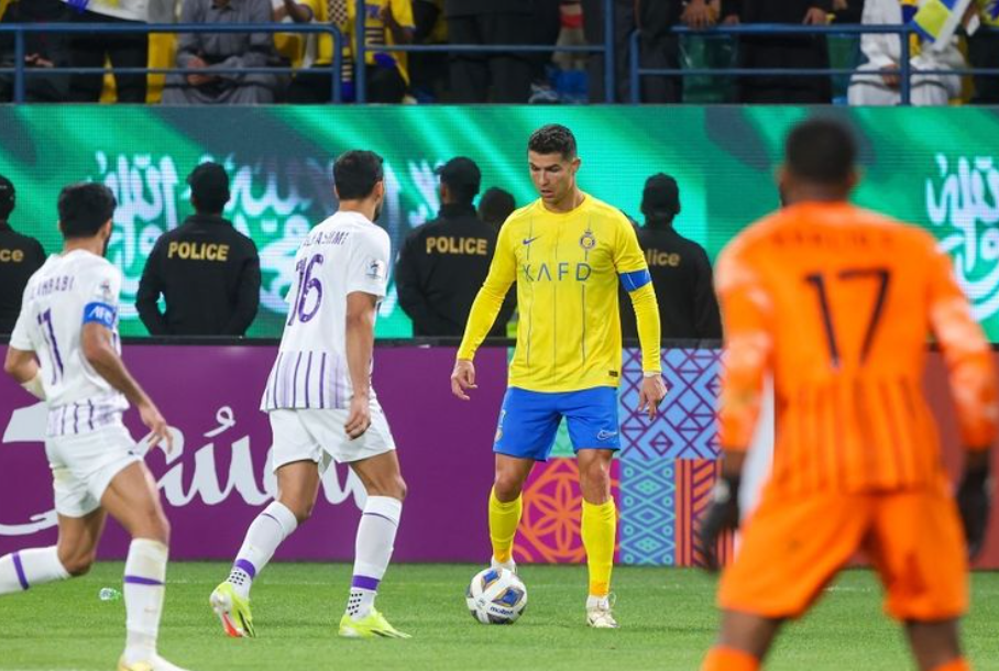 Penyerang Al Nassr Cristiano Ronaldo (kuning) terlihat menjaga bola selama pertandingan sepak bola Liga Champions Asia antara Al-Nassr vs Al-Ain di Stadion Al-Awal Park di Riyadh pada 11 Maret 2024.