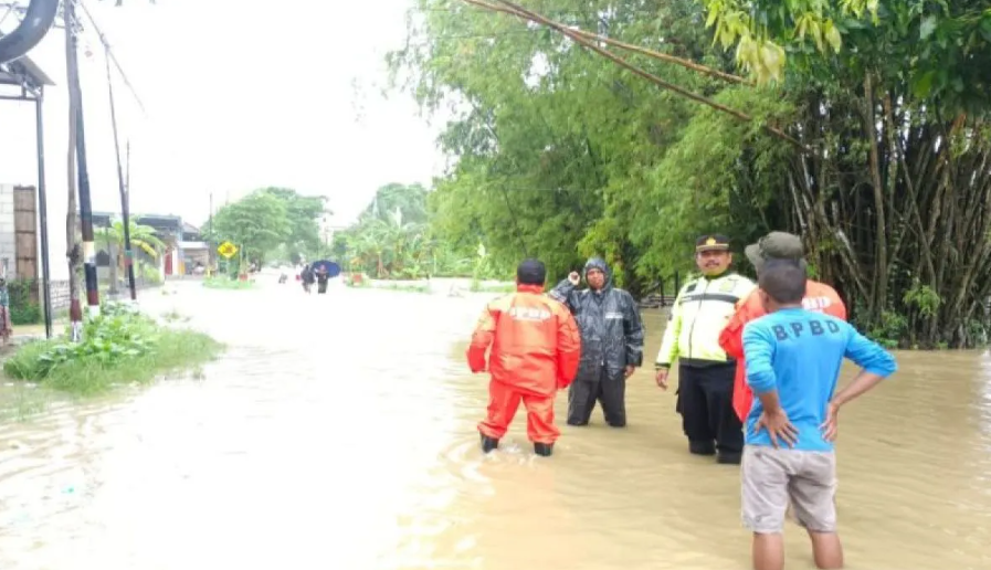 Sejumlah petugas berjaga-jaga di lokasi banjir di Jalan Raya Arosbaya, Bangkalan, Jawa Timur