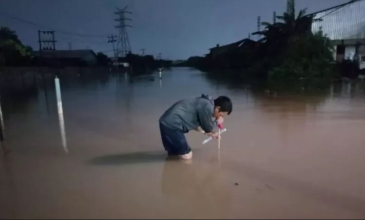 Petugas mengukur ketinggian banjir di jalur rel kereta api di wilayah Daop 4 Semarang, sehingga tidak bisa dilalui pada Kamis (14/3). (Antara)