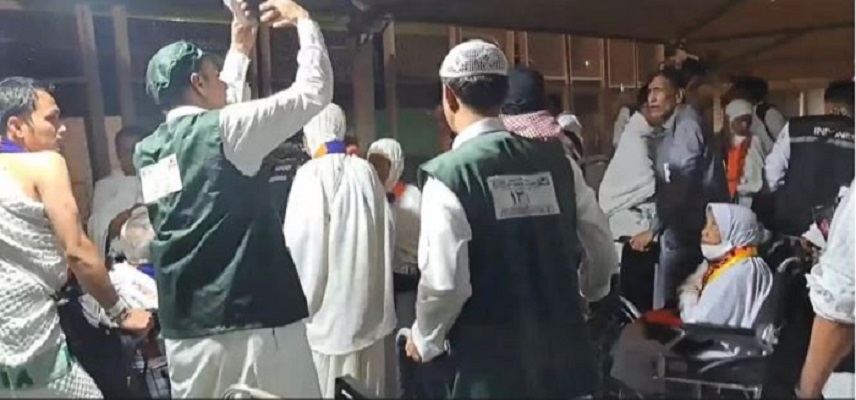 SERAGAM HIJAU: Dua petugas pendorong kereta berada di tengah-tengah rombongan jamaah haji asal Indonesia yang baru tiba di Terminal Syib Amir, Makkah. (Media Center Haji)