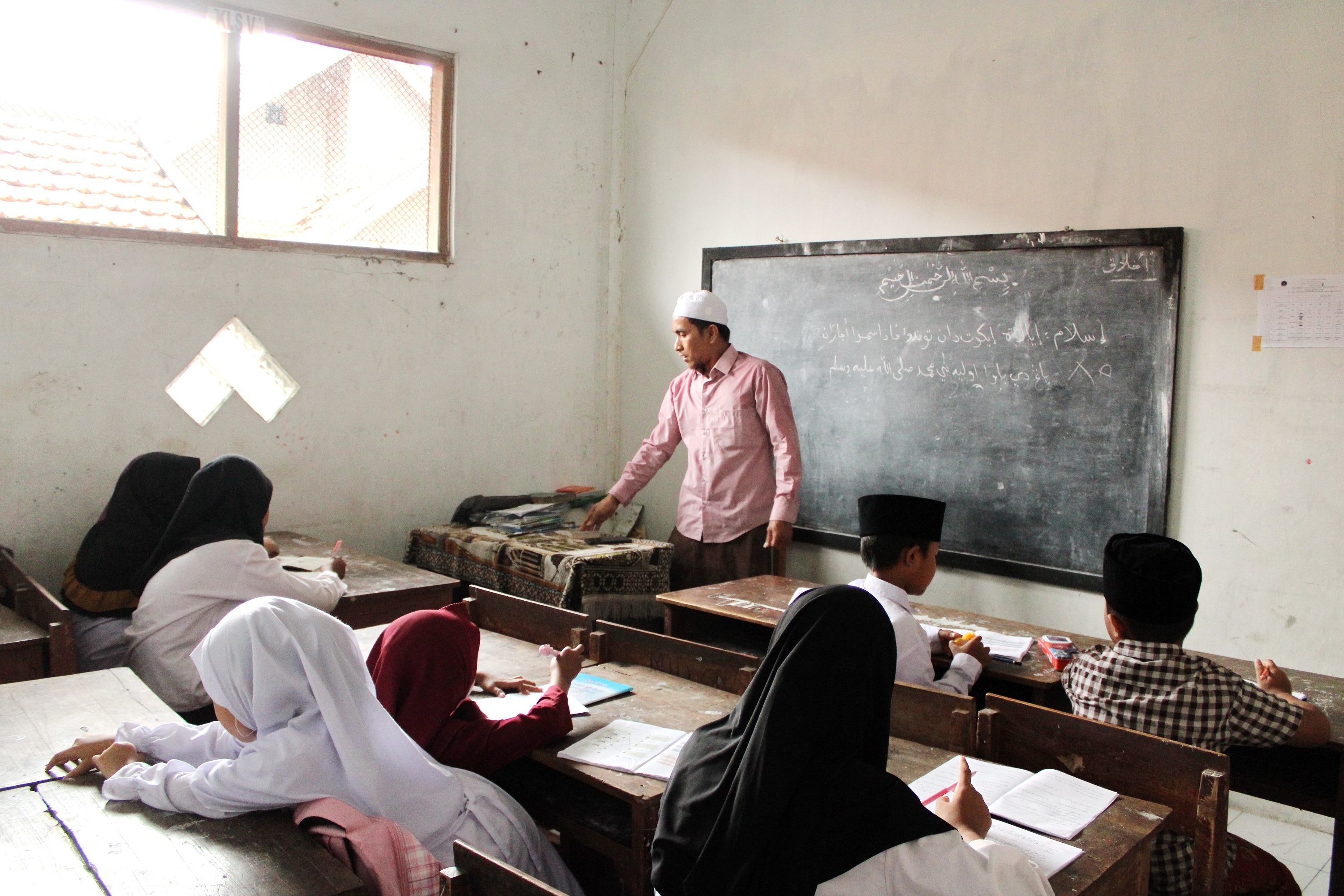 PROGRAM INSENTIF: Madisidi, guru ngaji Nurul Ulum, mengajar santrinya di Jalan Pemuda Kaffa, Bangkalan, Selasa (28/5). (VIVIN AGUSTIN HARTONO/JPRM)