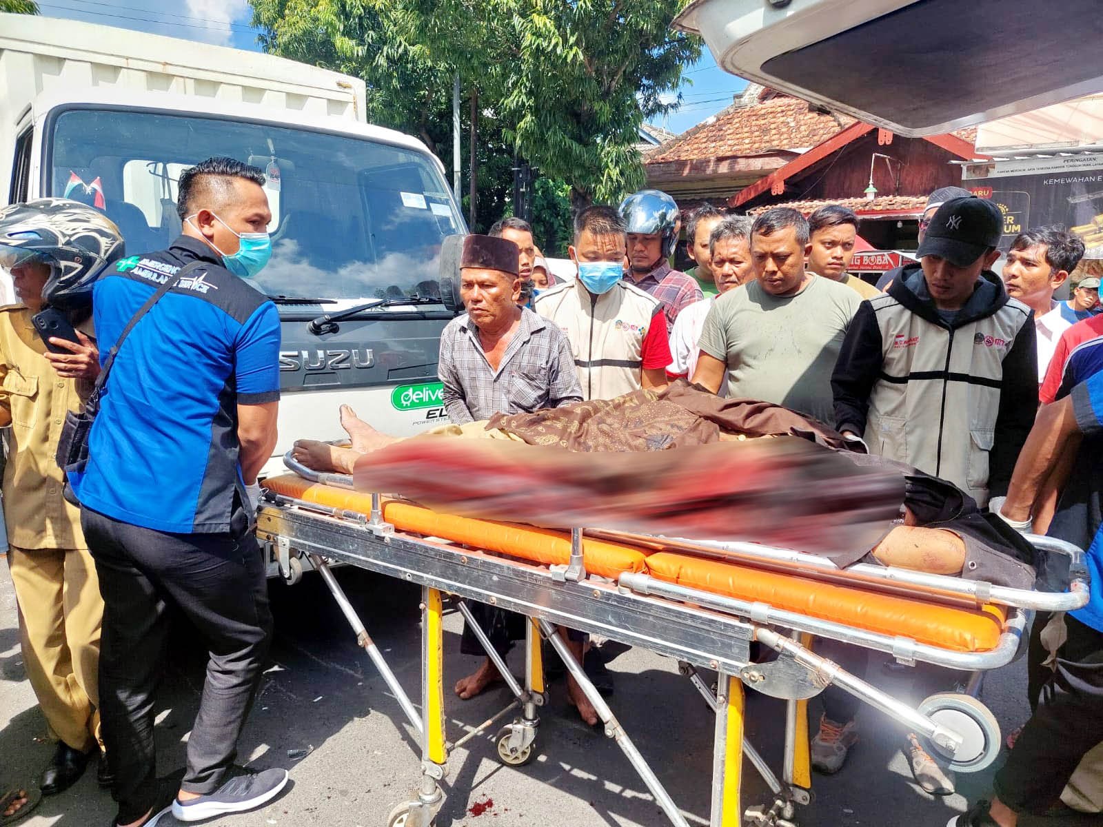TERLIBAT LAKA: Warga dan tim medis tengah mengevakuasi korban kecelakaan lalu lintas di Jalan Mayjen Sungkono, Bangkalan, kemarin. (ZEINAL ABIDIN/JPRM)