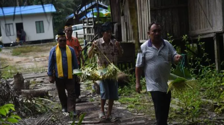 Warga suku Paser membawa sesaji saat ritual bersoyong di Kelurahan Sepaku, Kecamatan Sepaku, Kabupaten Penajam Paser Utara, Kalimantan Timur, Sabtu (27/7/2022). (Sumber: Bahana Patria Gupta/Kompas.id)