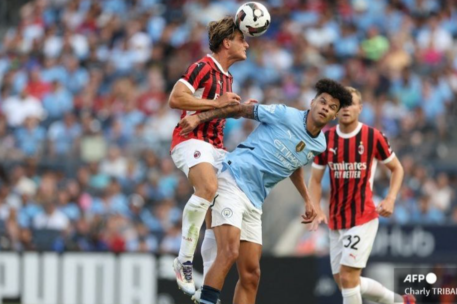 Penyerang AC Milan asal Italia, Lorenzo Colombo (L) berebut bola dengan gelandang Manchester City asal Inggris, Nico O