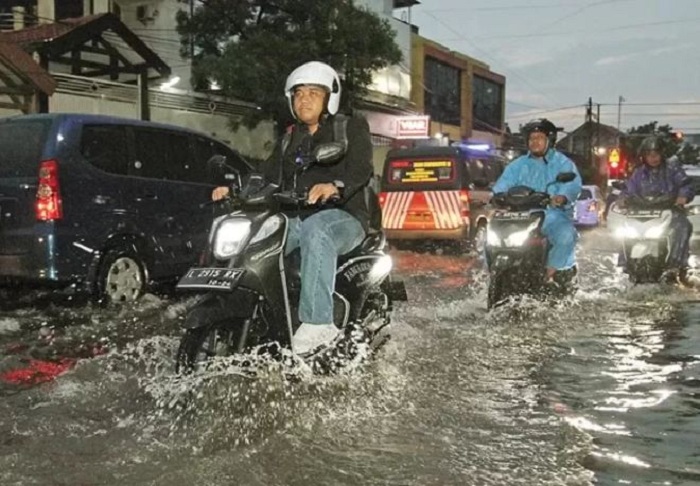 Ilustrasi pengendara sepeda motor menembus genangan banjir. (Robertus Risky/Jawa Pos)