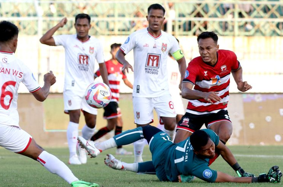 Pemain Madura United Koko Ari menendang bola yang dihalau penjaga gawang Malut United M Fahri saat laga pekan ke-1 Liga 1 2024-2025.