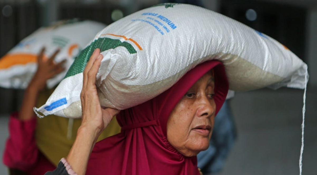 Warga penerima manfaat membawa karung berisi beras seberat 10 kg saat penyaluran bantuan beras di Kantor PT Pos Indonesia (Persero) Banda Aceh, Aceh, Sabtu (12/10/2024). ANTARA FOTO/Ampelsa.