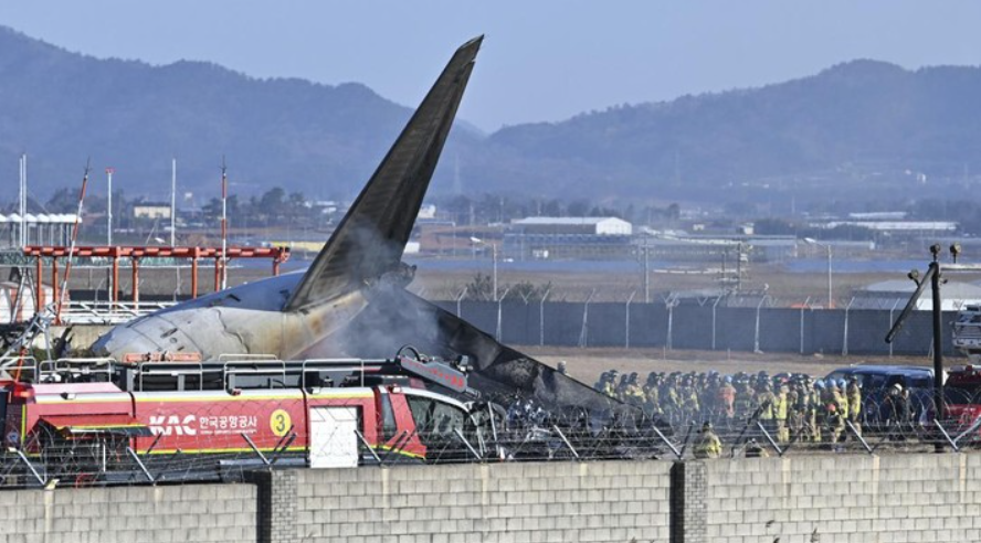 Foto: Petugas pemadam kebakaran dan anggota tim penyelamat bekerja di landasan pacu Bandara Internasional Muan di Muan, Korea Selatan, Minggu, 29 Desember 2024. (AP/Lee Young-ju)