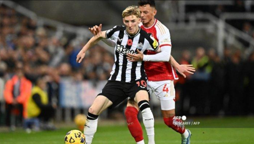 Gelandang Newcastle United #10 Anthony Gordon (Kiri) menjauhi kejaran bek Arsenal #04 Ben White (kanan) selama pertandingan sepak bola Liga Utama Inggris di St James